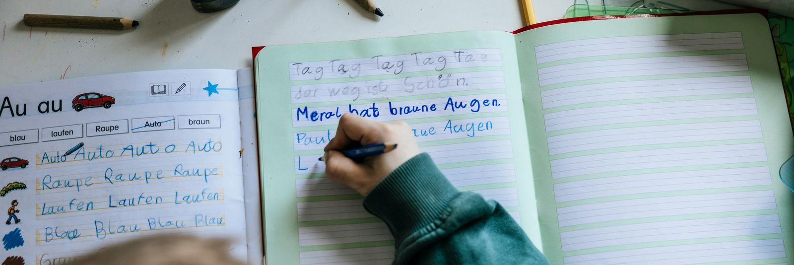 a person writing on a notebook with a pen
