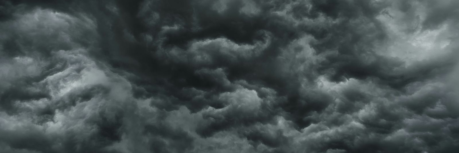Dense dark grey storm clouds filling the sky with swirling patterns