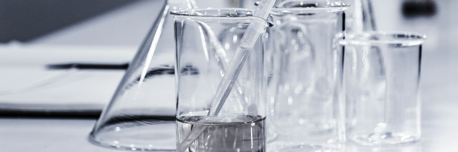 three clear beakers placed on tabletop